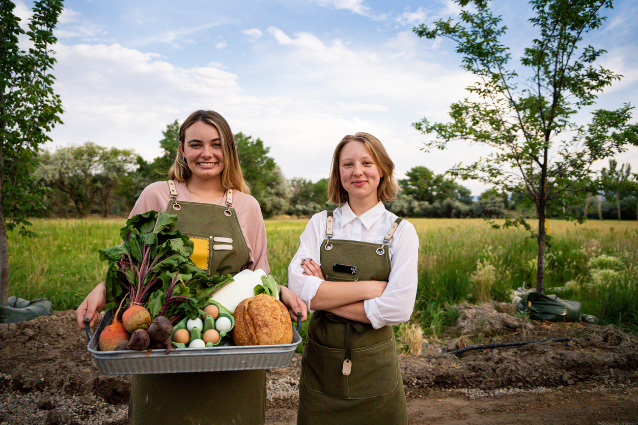 2 female farmers holding vegetables