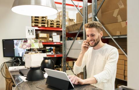 man on phone and using computer