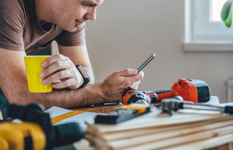 trades man reading his phone